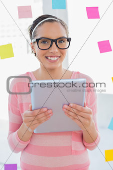 Smiling artist holding tablet and looking at camera