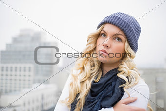 Cold blonde in winter clothes posing outdoors