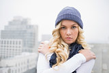 Shivering blonde in winter clothes posing outdoors