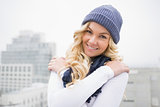 Smiling blonde in winter clothes posing outdoors
