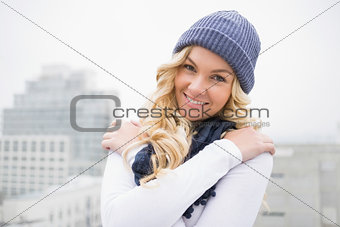 Smiling blonde in winter clothes posing outdoors