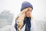 Thoughtful blonde in winter clothes posing outdoors