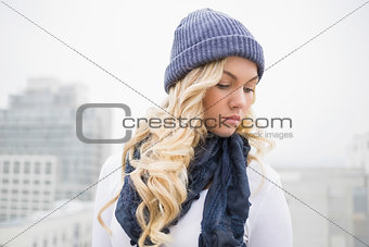 Thoughtful blonde in winter clothes posing outdoors