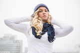 Serious blonde in winter clothes posing outdoors
