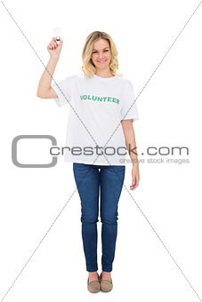 Happy blonde volunteer holding light bulb