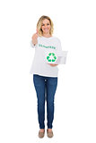 Smiling blonde volunteer holding recycling box giving thumb up to camera