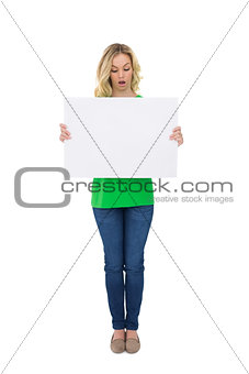 Shocked cute blonde holding white sign