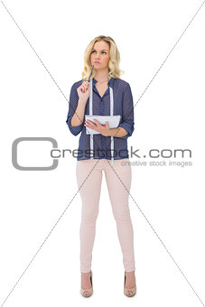 Thoughtful pretty fashion designer holding sketchpad