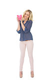 Smiling pretty blonde holding piggy bank
