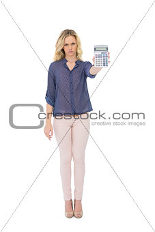 Frowning pretty blonde showing calculator