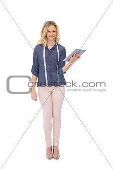 Smiling pretty fashion designer holding tablet