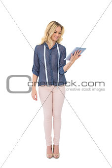 Cheerful pretty fashion designer holding tablet