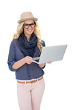 Cheerful trendy blonde holding laptop