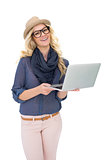 Happy trendy blonde holding laptop