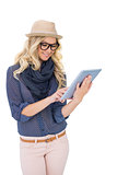 Smiling trendy blonde using tablet computer