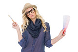 Pensive trendy blonde with classy glasses holding color chart