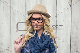 Pensive trendy blonde holding pencil