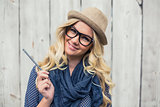 Smiling trendy blonde holding pencil
