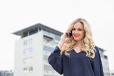 Smiling gorgeous blonde with red lips on the phone