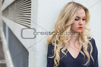 Pensive attractive blonde wearing classy dress outdoors