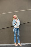 Thinking casual blonde wearing denim clothes posing outdoors