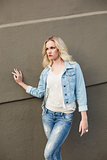 Serious casual blonde wearing denim clothes posing outdoors