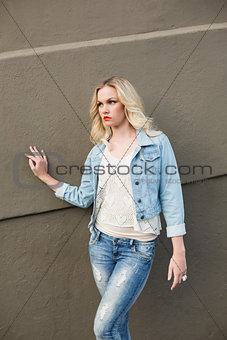 Serious casual blonde wearing denim clothes posing outdoors