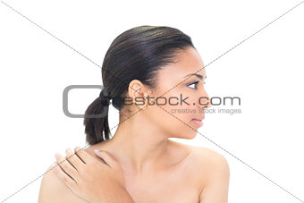 Profile view of a stern black haired model holding her shoulder