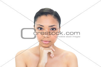 Unsmiling young dark haired model holding her chin