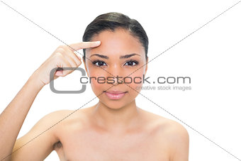 Charming young dark haired model pointing her brow with her finger