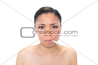 Frowning young dark haired model using a thermometer