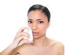 Charming young dark haired model using asthma inhaler