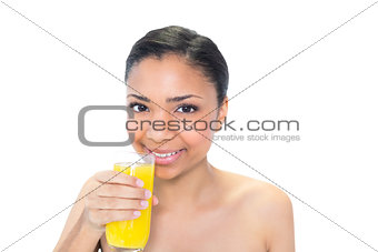Happy young dark haired model drinking orange juice
