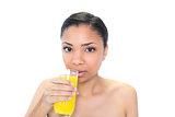 Beautiful young dark haired model drinking orange juice