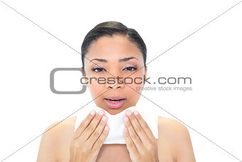 Pretty young dark haired model sneezing in a tissue