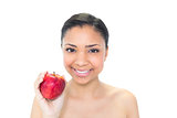 Delighted young dark haired model holding a red apple