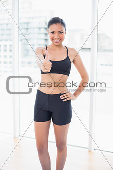 Content dark haired model in sportswear giving a thumb up