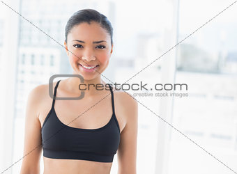 Cheerful dark haired model in sportswear posing looking at camera