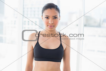 Serious dark haired model in sportswear posing looking at camera