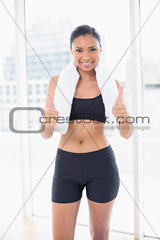 Confident dark haired model in sportswear giving thumbs up