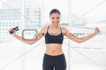 Pretty dark haired model in sportswear holding a skipping rope