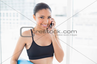 Athletic dark haired model in sportswear making a phone call