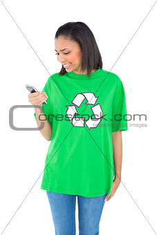 Pleased dark haired environmental activist looking at her mobile phone