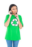Pensive dark haired environmental activist making a phone call
