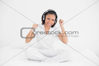 Dynamic young dark haired model listening to music with headphones