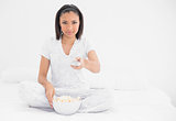 Relaxed young dark haired model eating popcorn