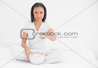 Relaxed young dark haired model eating popcorn