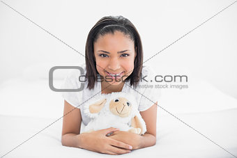 Pretty young dark haired model cuddling a plush sheep