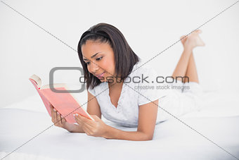 Concentrated young dark haired model reading a book