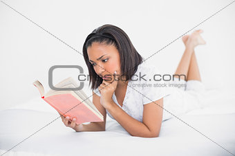 Focused young dark haired model reading a book